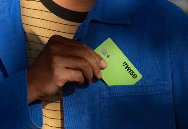 Person puts their Wise card in the pocket of their coat
