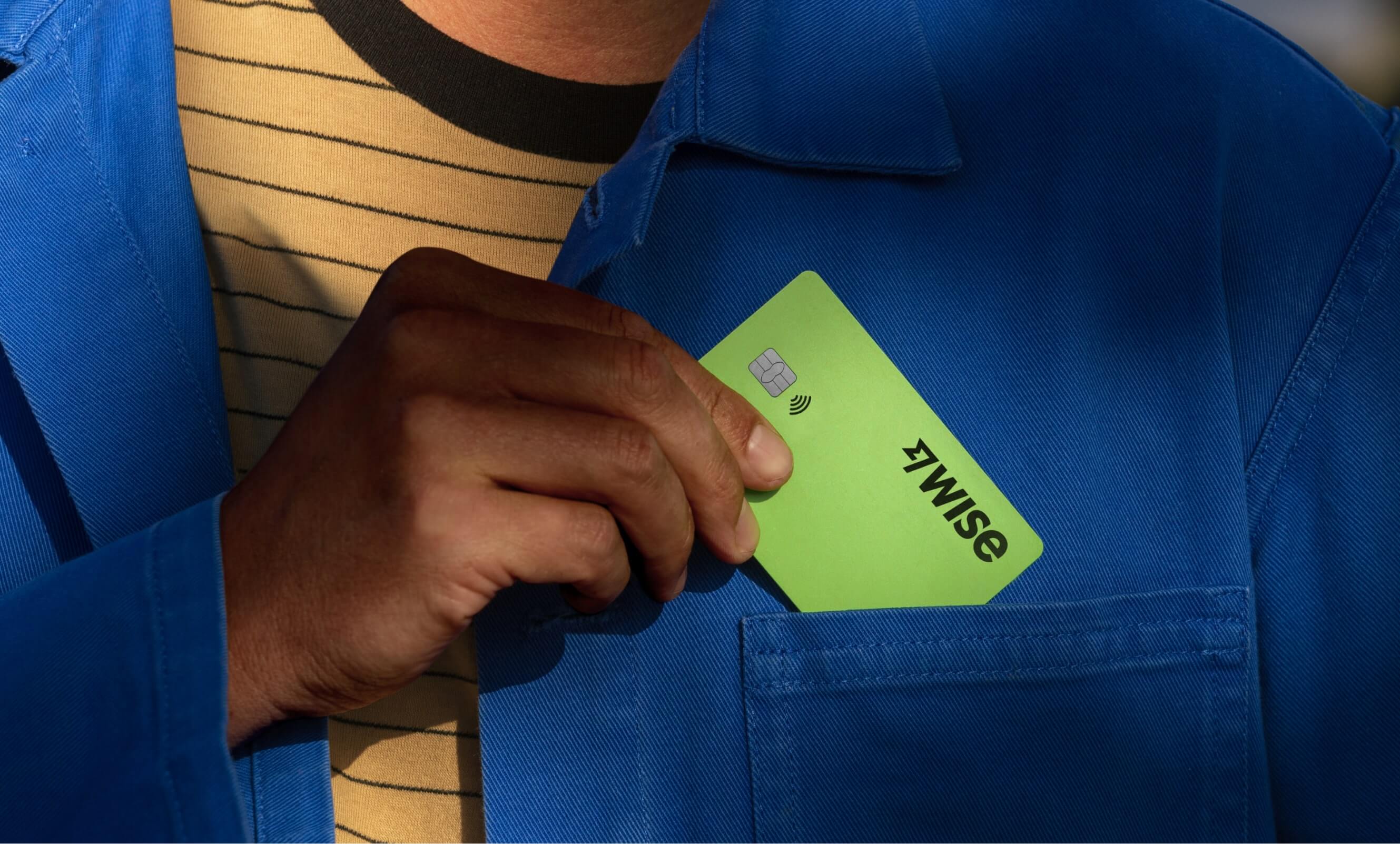 Person puts their Wise card in the pocket of their coat