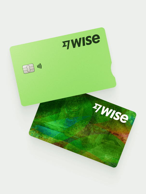 Two Wise debit cards on a green background.